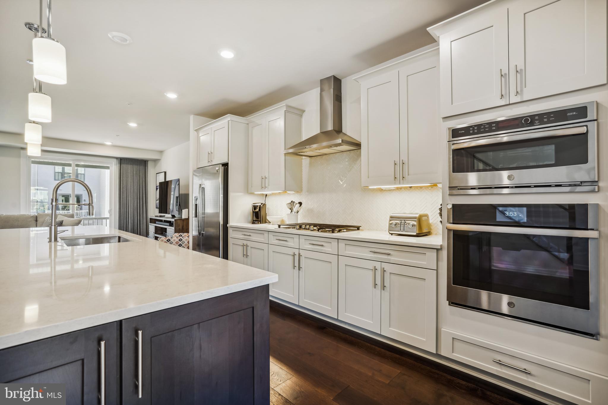 43469 Grandmoore Street Ashburn, VA 20148 - Photo 15 of 62 a kitchen with kitchen island granite countertop a stove cabinets and sink