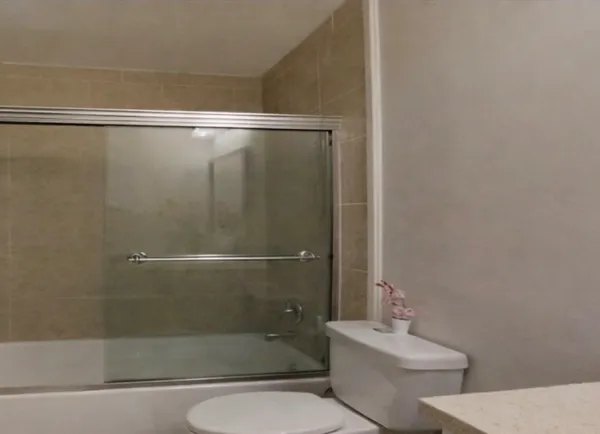 a bathroom with a toilet and a shower