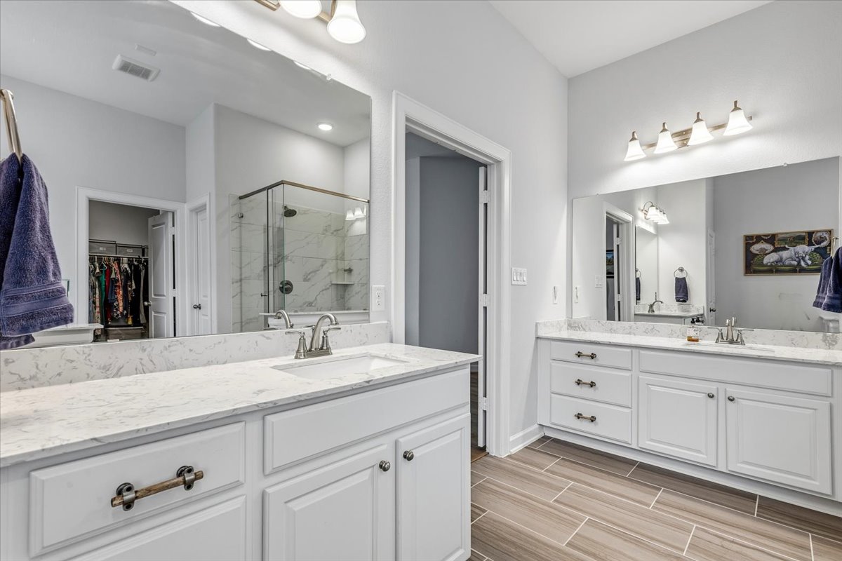 1029 Wild Pecan Loop Buda, TX 78610 - Photo 17 of 37 a bathroom with a sink double vanity granite tub shower and a mirror