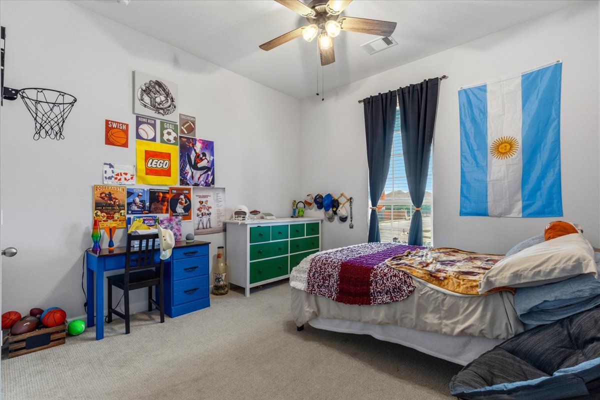 1029 Wild Pecan Loop Buda, TX 78610 - Photo 25 of 37 a bedroom with a bed and a chandelier