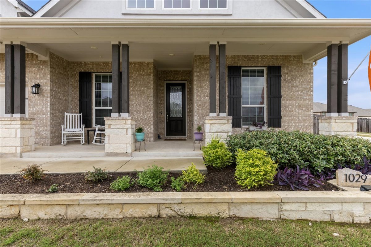 1029 Wild Pecan Loop Buda, TX 78610 - Photo 4 of 37 a front view of a house with lots of potted plants