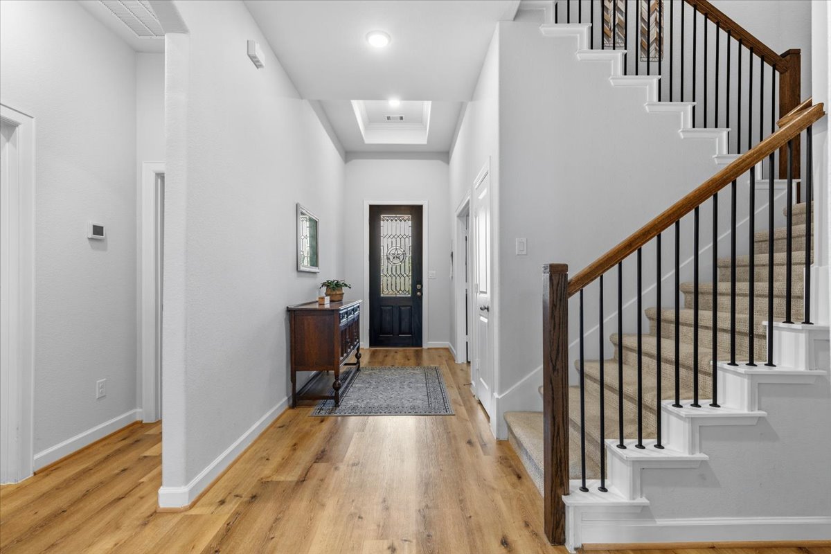 1029 Wild Pecan Loop Buda, TX 78610 - Photo 5 of 37 a view of a hallway view with wooden floor and staircase