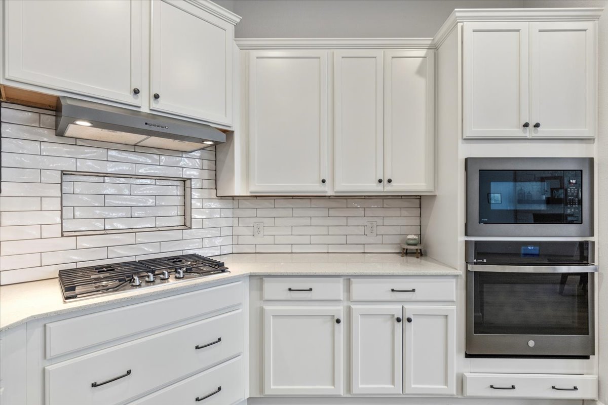 1029 Wild Pecan Loop Buda, TX 78610 - Photo 9 of 37 a kitchen with granite countertop white cabinets and appliances