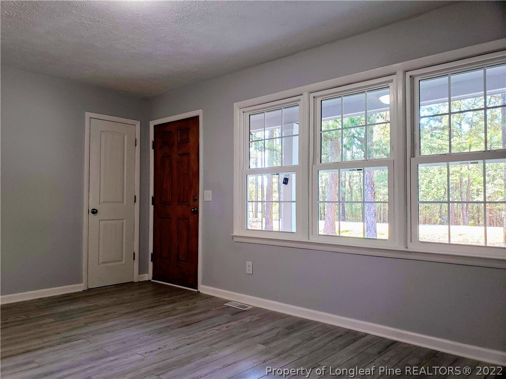 711 Reservation Road Aberdeen, NC 28315 - Photo 4 of 19 a view of an empty room with wooden floor and a window