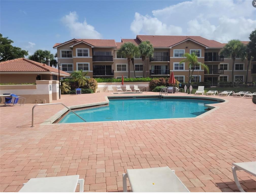 8741 Wiles Road, Unit 305 Coral Springs, FL 33067 - Photo 13 of 20 a view of a house with swimming pool