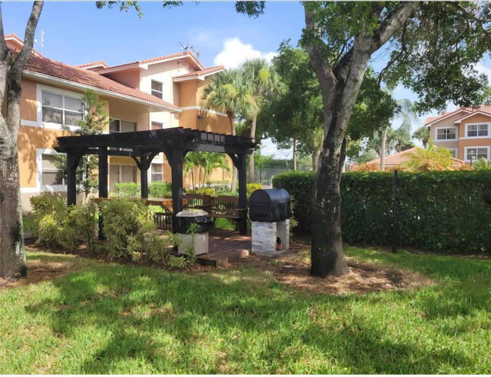 8741 Wiles Road, Unit 305 Coral Springs, FL 33067 - Photo 17 of 20 a front view of a house with garden