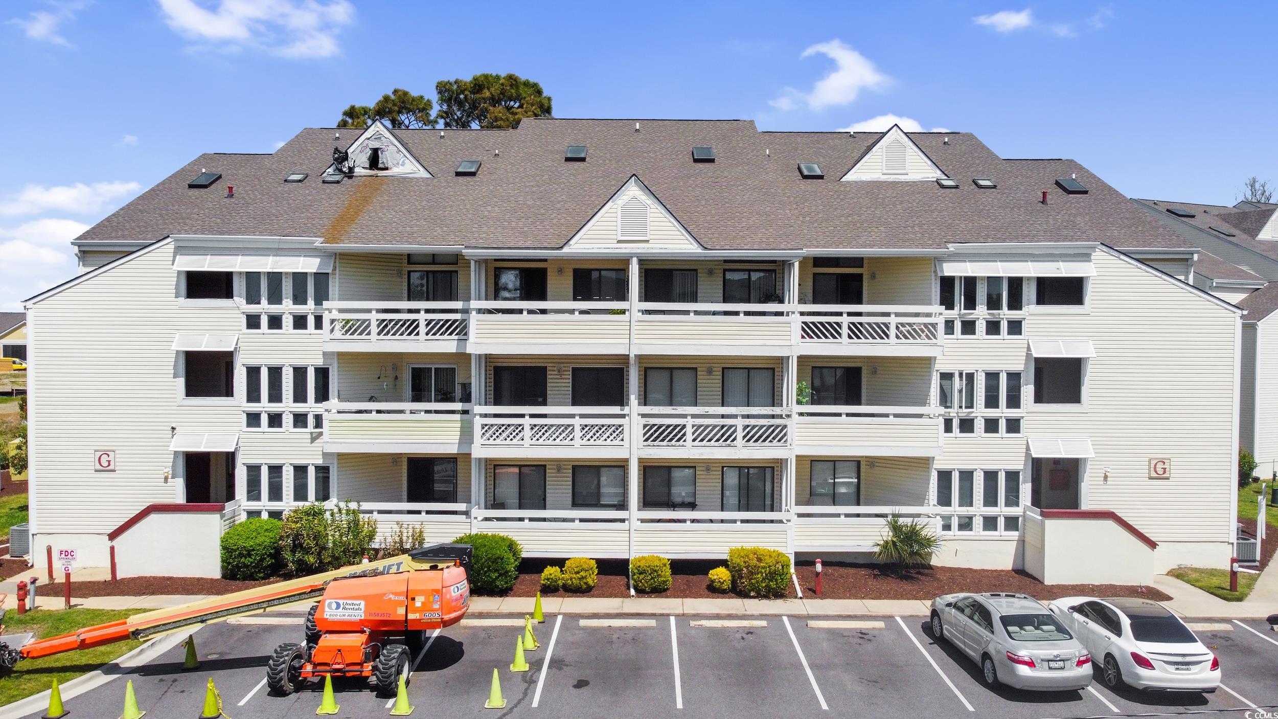 View of building exterior with uncovered parking