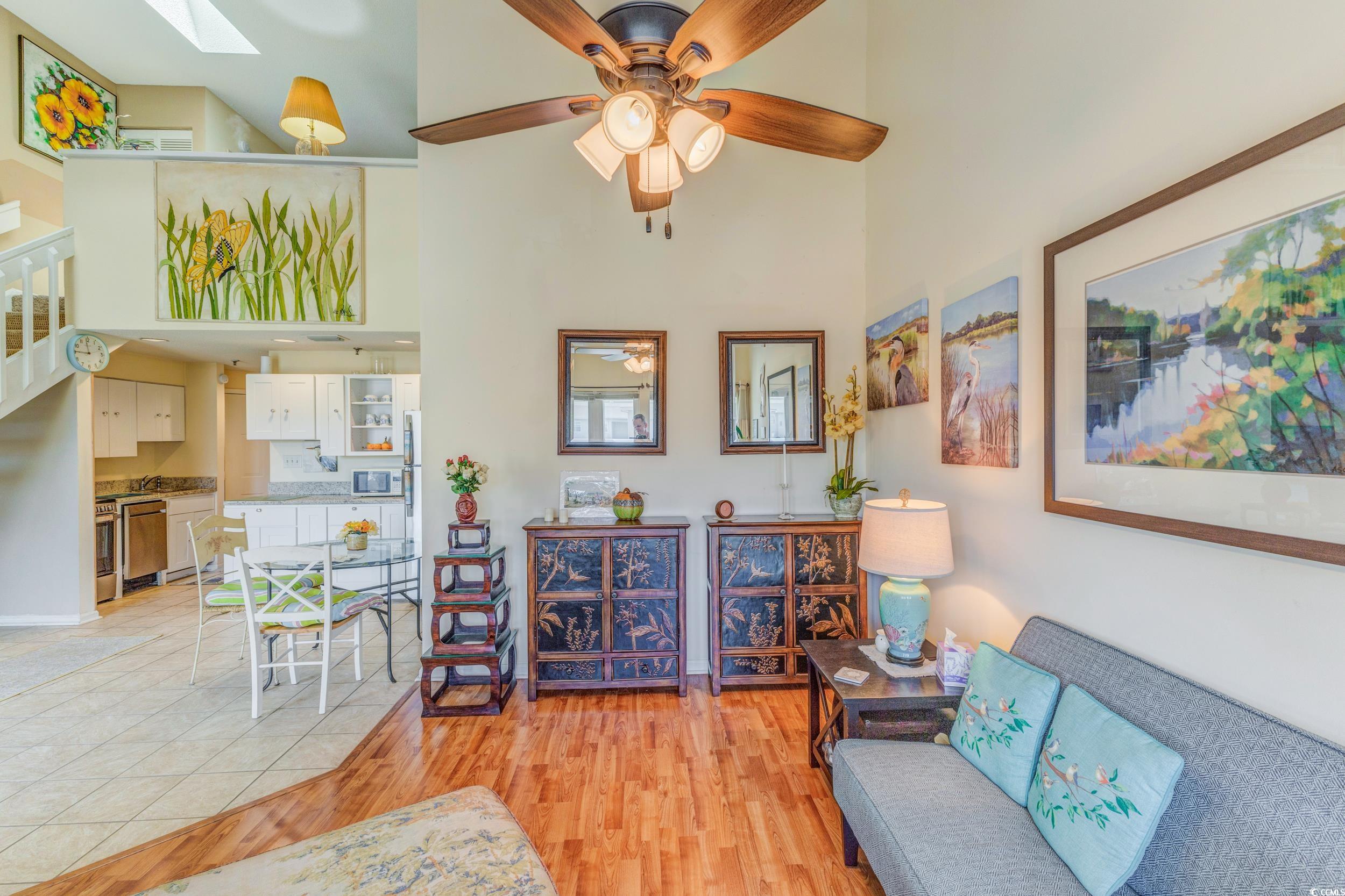 1100 Possum Trot Road, Unit G326 North Myrtle Beach, SC 29582 - Photo 7 of 21 Living room with light wood-style floors, ceiling fan, a towering ceiling, and a skylight