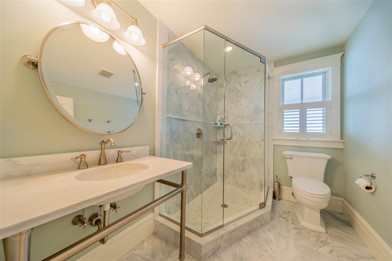 498 7th Street Avalon, NJ 08202 - Photo 6 of 36 a bathroom with a sink mirror and a shower