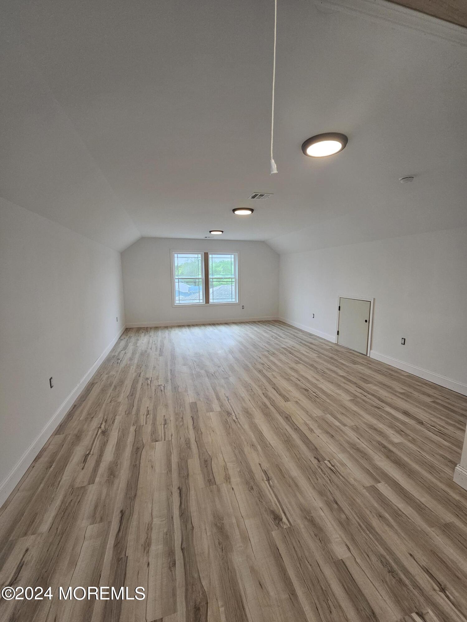 91 Illinois Avenue Waretown, NJ 08758 - Photo 12 of 12 a view of empty room with wooden floor and fan