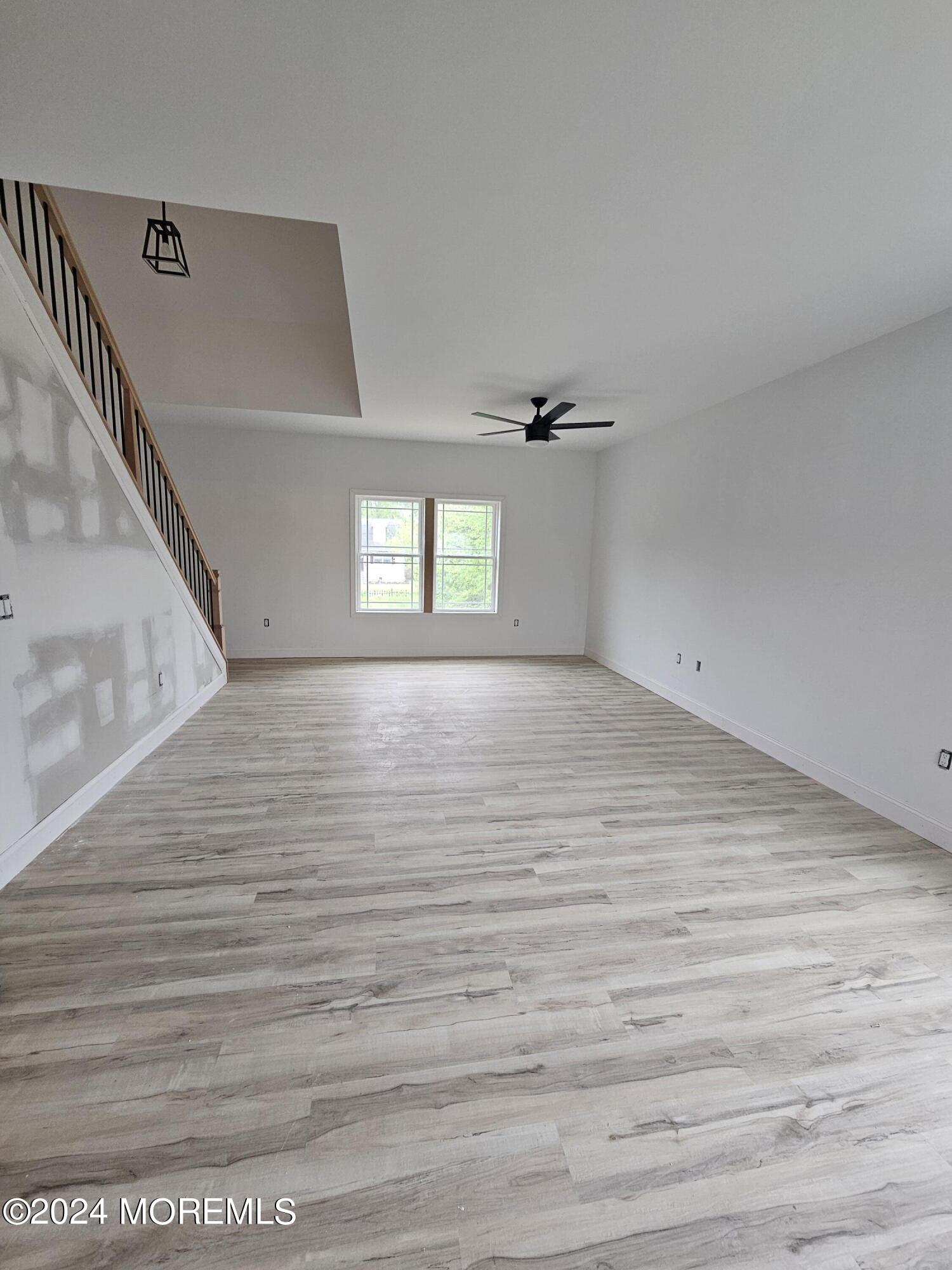 91 Illinois Avenue Waretown, NJ 08758 - Photo 4 of 12 a view of an empty room with wooden floor and a window