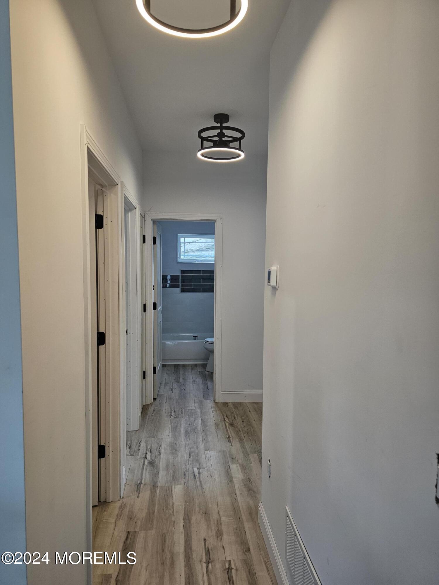 91 Illinois Avenue Waretown, NJ 08758 - Photo 5 of 12 a view of a hallway with wooden floor