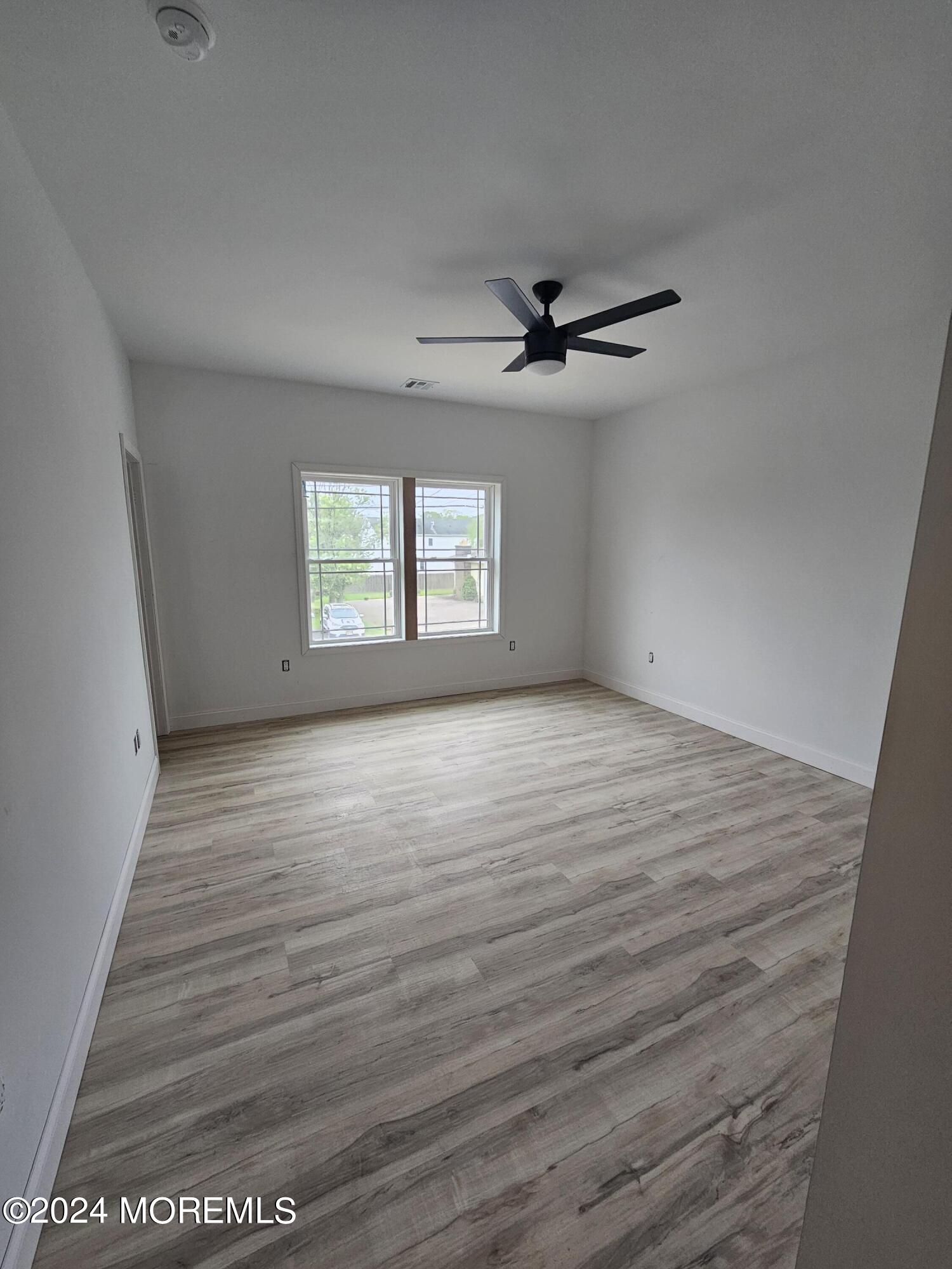 91 Illinois Avenue Waretown, NJ 08758 - Photo 6 of 12 wooden floor in an empty room with a window