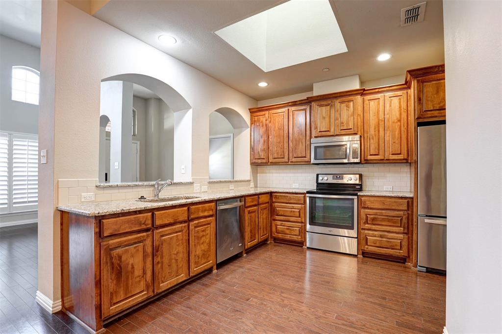 5633 Hummingbird Lane Fairview, TX 75069 - Photo 11 of 25 a large kitchen with stainless steel appliances granite countertop a stove and a sink
