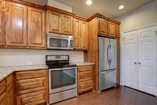 a kitchen with granite countertop wooden cabinets and stainless steel appliances