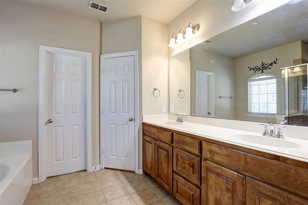 5633 Hummingbird Lane Fairview, TX 75069 - Photo 16 of 25 a spacious bathroom with a double vanity sink a large mirror and a bathtub