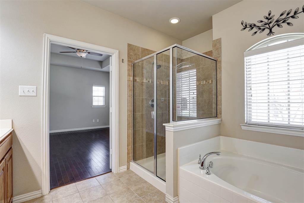 5633 Hummingbird Lane Fairview, TX 75069 - Photo 18 of 25 a bathroom with a bathtub and a shower