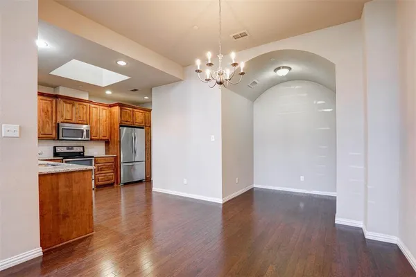 a view of a kitchen with stainless steel appliances a wooden floor