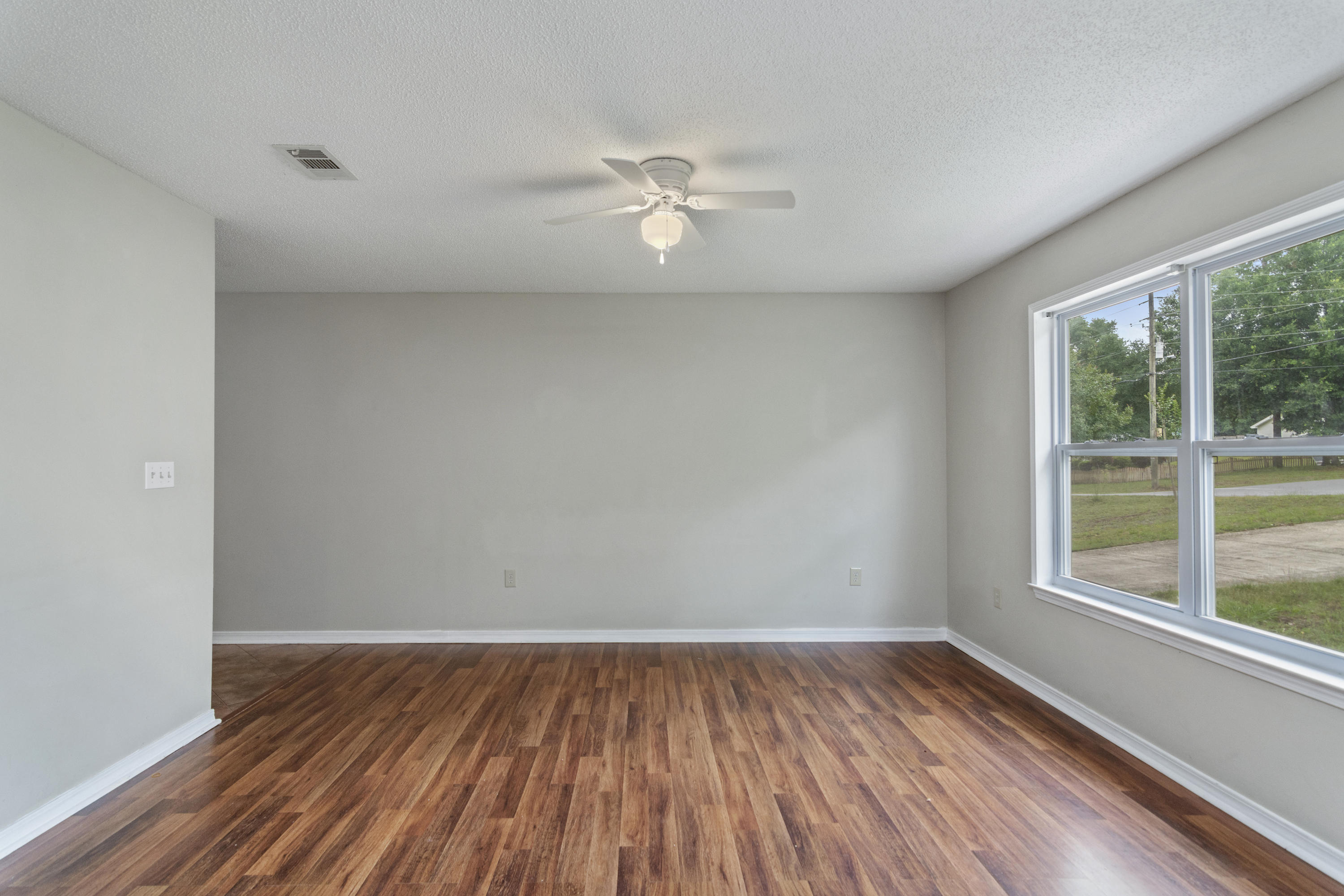 384 John King Road Crestview, FL 32539 - Photo 3 of 21 wooden floor in an empty room with a window