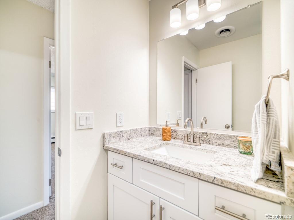 2730 West Mississippi Avenue, Unit 8 Denver, CO 80219 - Photo 13 of 40 a bathroom with a granite countertop sink and a mirror