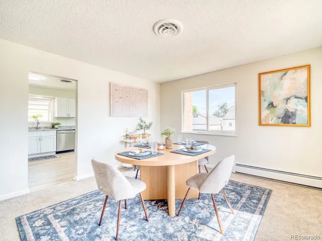 a dining room with wooden floor and a chandelier