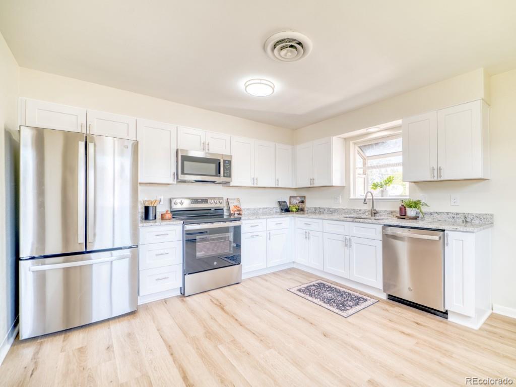 2730 West Mississippi Avenue, Unit 8 Denver, CO 80219 - Photo 3 of 40 a kitchen with granite countertop a refrigerator stove top oven and sink