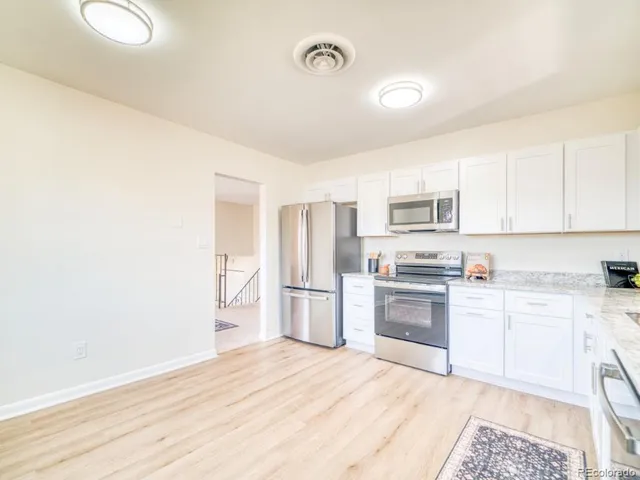 a kitchen with a refrigerator stove top oven and sink
