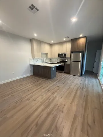 a view of kitchen with refrigerator microwave and wooden floor