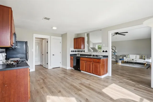 a kitchen with stainless steel appliances granite countertop a stove a sink a refrigerator and a wooden cabinets