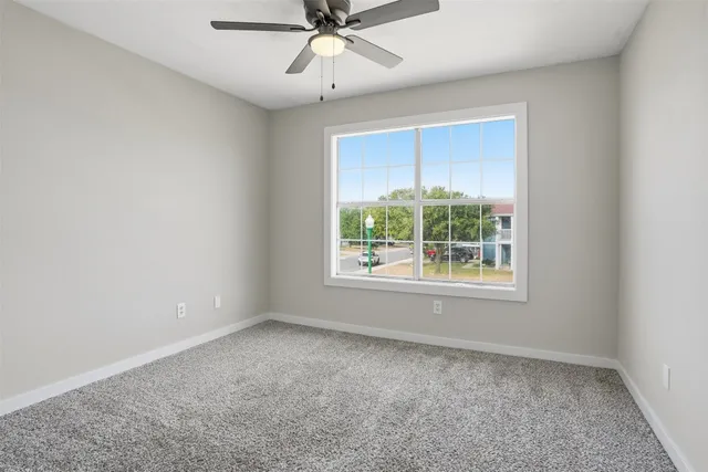 an empty room with a window and a fan