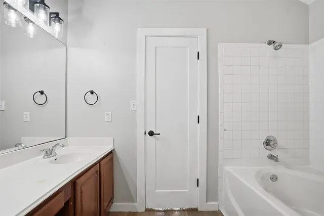 a bathroom with a tub sink shower and mirror