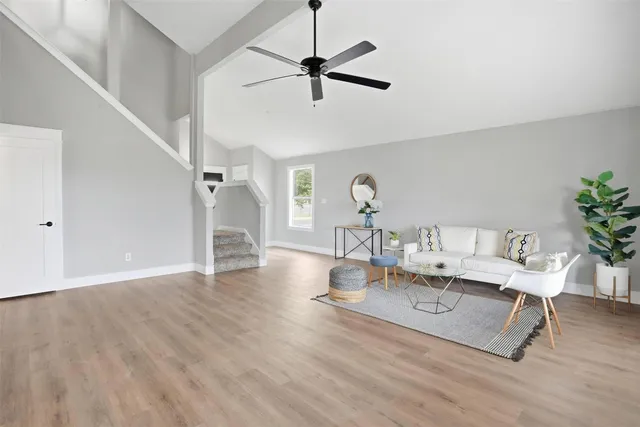 a dining room with wooden floor a chandelier fan a wooden table and chairs