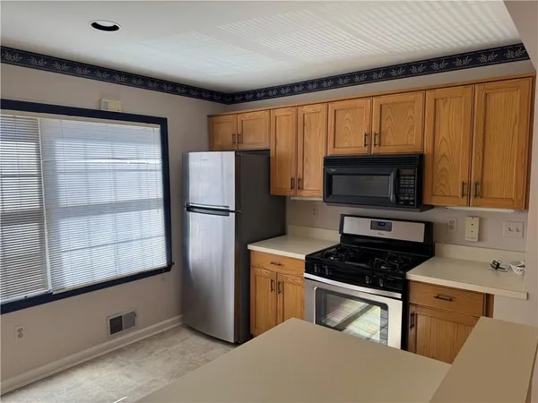 a kitchen with stainless steel appliances granite countertop a refrigerator a stove a sink and a microwave