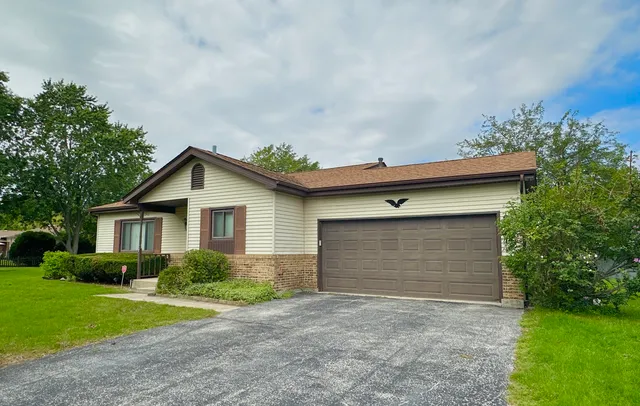 a front view of house with yard and trees around