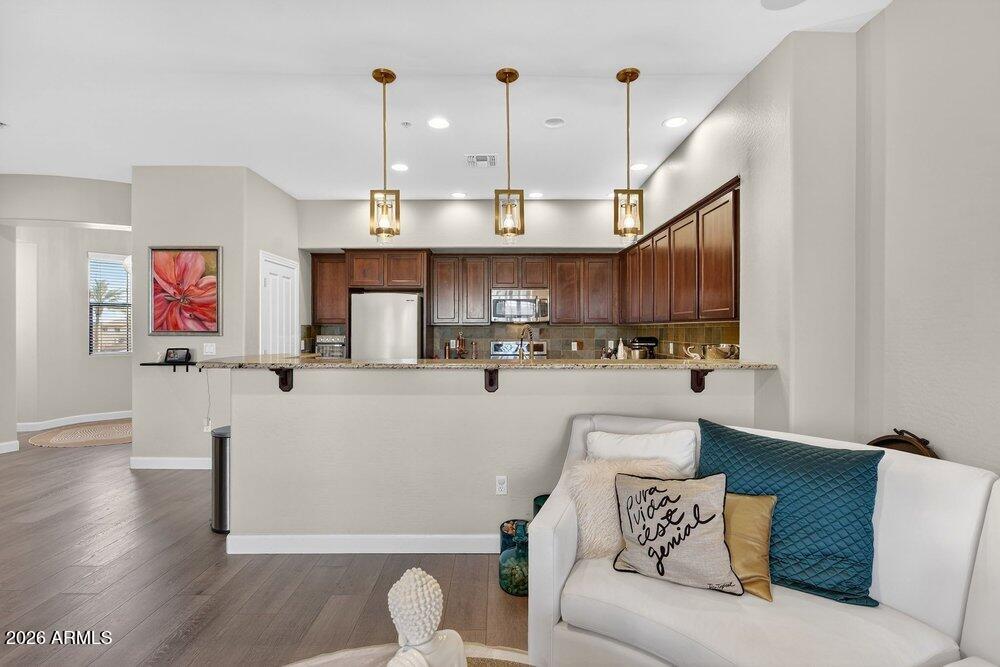 4777 South Fulton Ranch Boulevard, Unit 2035 Chandler, AZ 85248 - Photo 10 of 51 a living room with stainless steel appliances kitchen island granite countertop furniture and a wooden floor