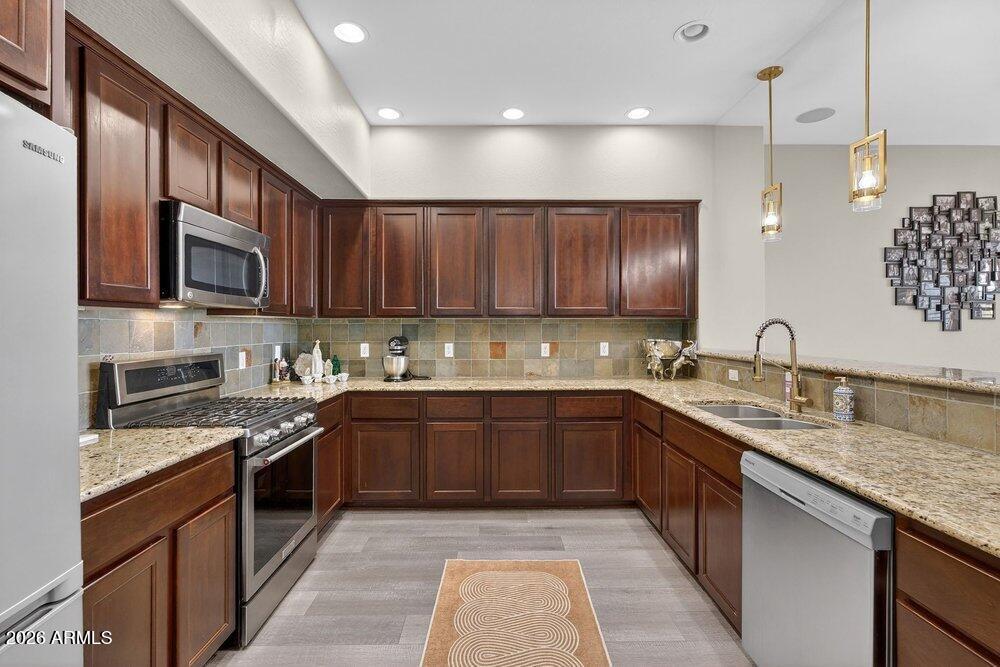 4777 South Fulton Ranch Boulevard, Unit 2035 Chandler, AZ 85248 - Photo 15 of 51 a kitchen with stainless steel appliances granite countertop wooden cabinets a stove top oven a sink and dishwasher