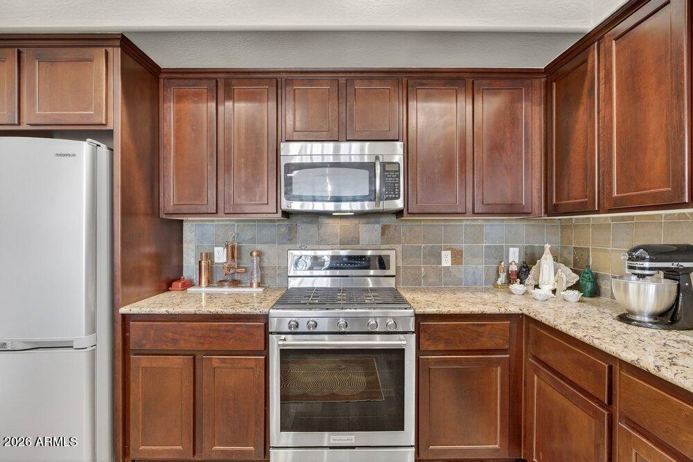 4777 South Fulton Ranch Boulevard, Unit 2035 Chandler, AZ 85248 - Photo 16 of 51 a kitchen with granite countertop cabinets stainless steel appliances and a window