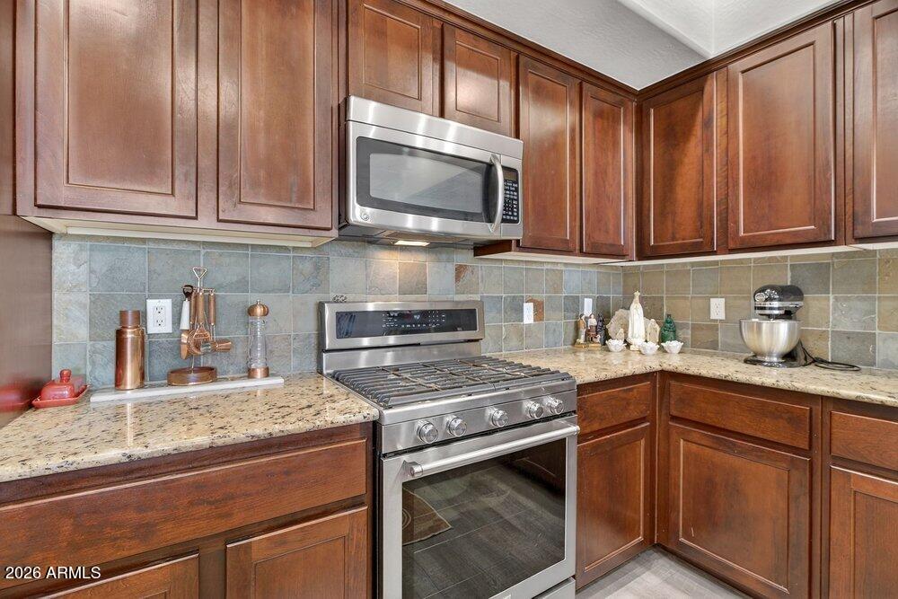 4777 South Fulton Ranch Boulevard, Unit 2035 Chandler, AZ 85248 - Photo 17 of 51 a kitchen with stainless steel appliances granite countertop a sink stove and microwave
