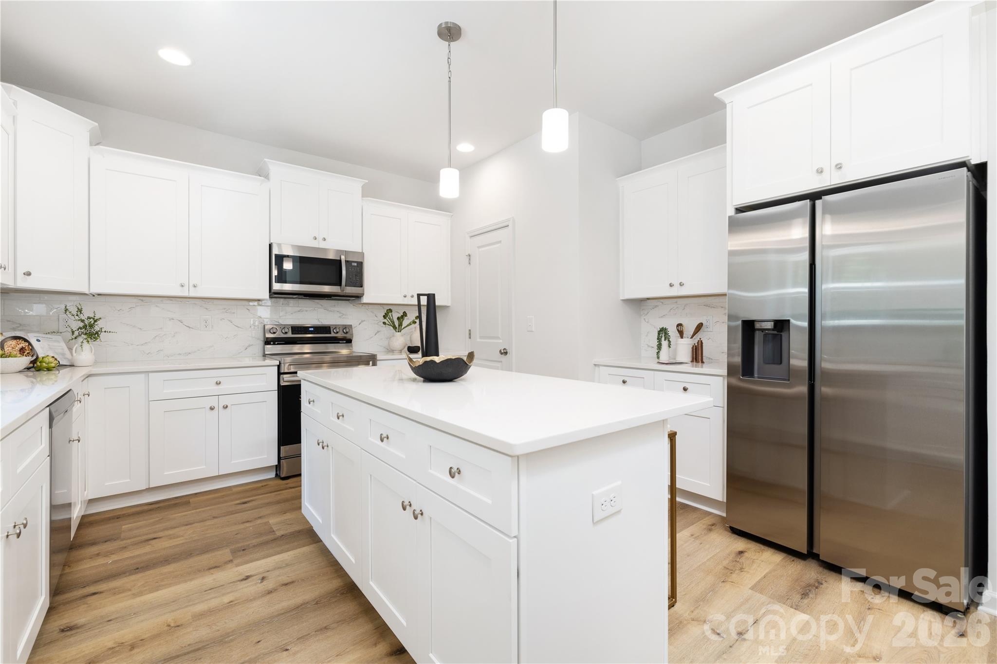 10606 Arlington Church Road Mint Hill, NC 28227 - Photo 12 of 26 a kitchen with kitchen island a white counter top space cabinets and stainless steel appliances
