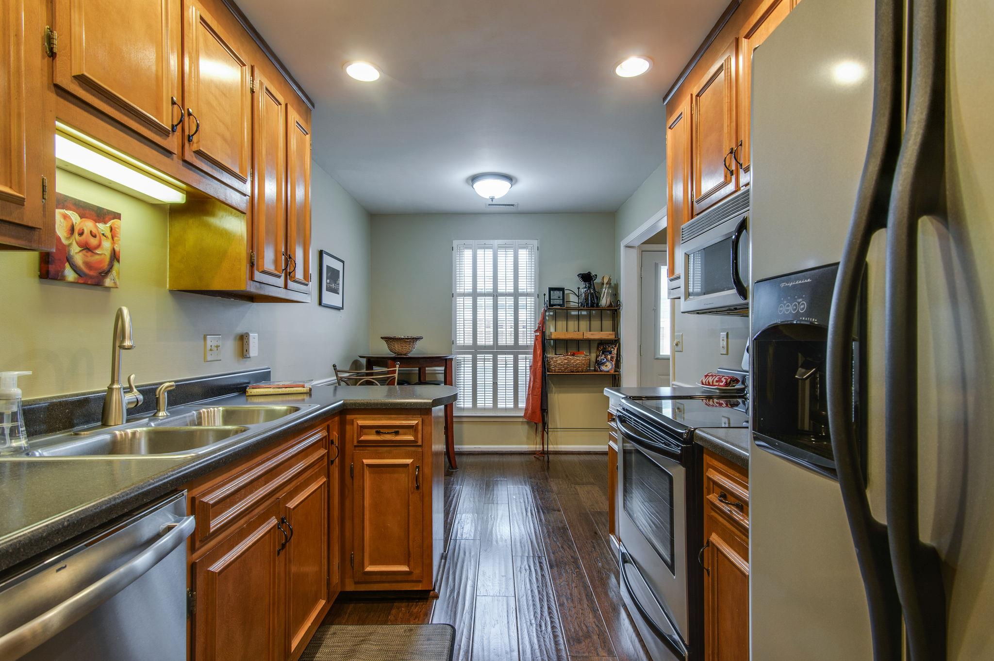 949 General George Patton Road Nashville, TN 37221 - Photo 15 of 25 a kitchen with stainless steel appliances granite countertop a refrigerator a sink dishwasher a stove and white countertops with wooden floor