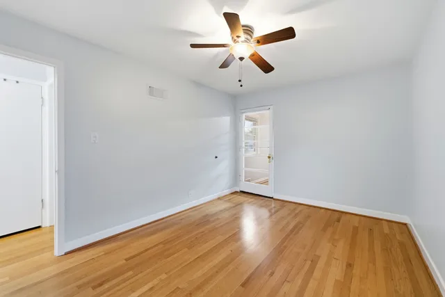 a kitchen with stainless steel appliances granite countertop a refrigerator a stove a microwave oven a sink with island and chairs with wooden floor