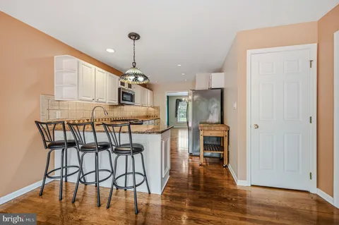 a view of a kitchen with furniture and wooden floor