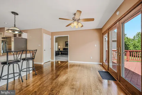a dining room with furniture a chandelier and wooden floor