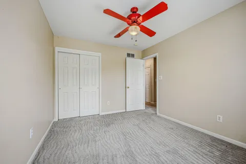 an empty room with wooden floor and ceiling fan