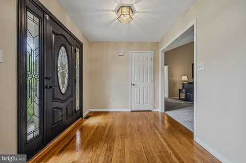 a view of a hallway with wooden floor and dining room