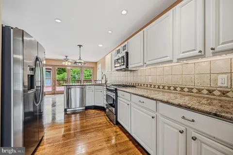 a kitchen with stainless steel appliances granite countertop a refrigerator sink and cabinets