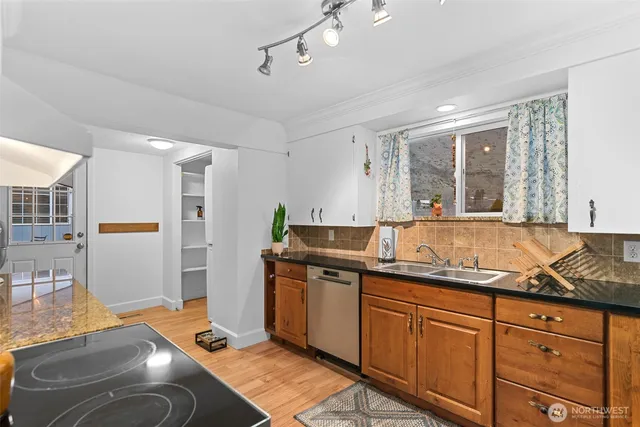 a kitchen with granite countertop cabinets a sink and stainless steel appliances