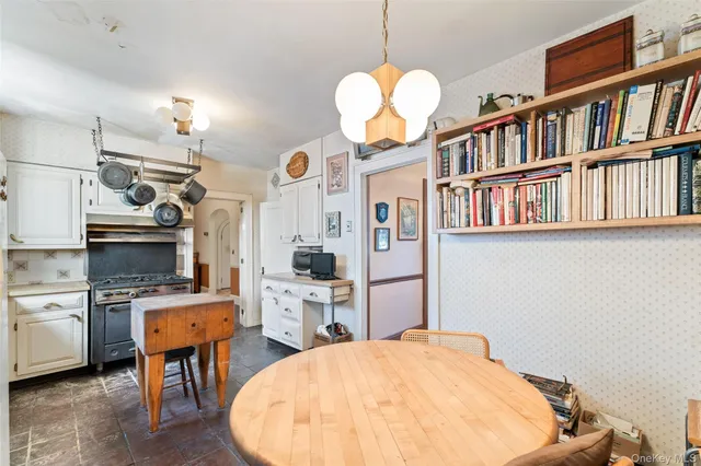 a very nice looking room with kitchen island stainless steel appliances furniture a fireplace and a bookshelf