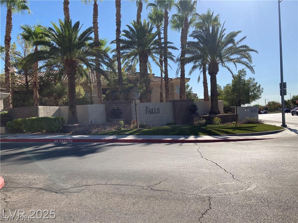 9050 West Warm Springs Road, Unit 1027 Las Vegas, NV 89148 - Photo 44 of 44 Mature palm trees line the entrance to a desert-landscaped community, offering a warm welcome.