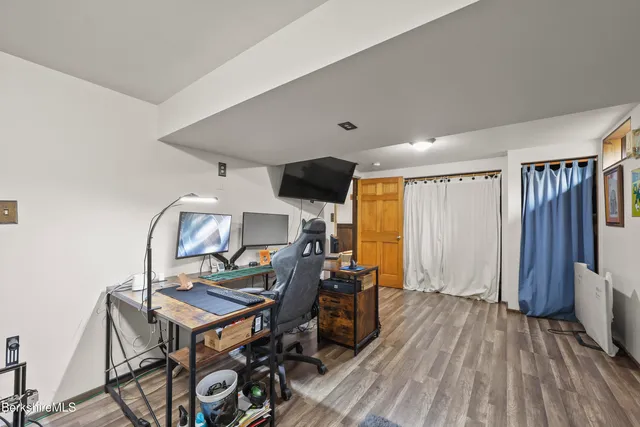 a view of a workspace with furniture and wooden floor